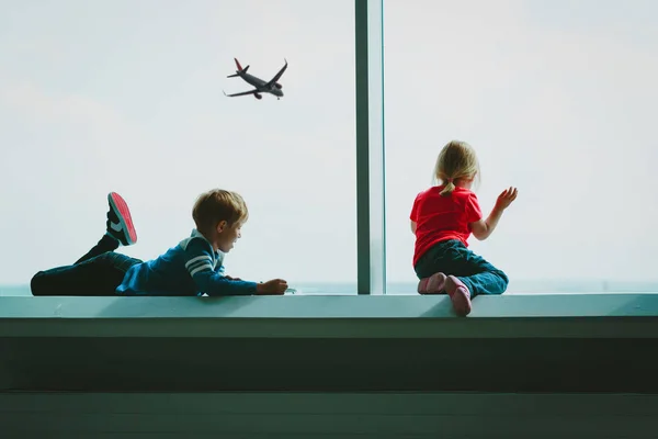Niños mirando avión en el aeropuerto, viajes en familia —  Fotos de Stock