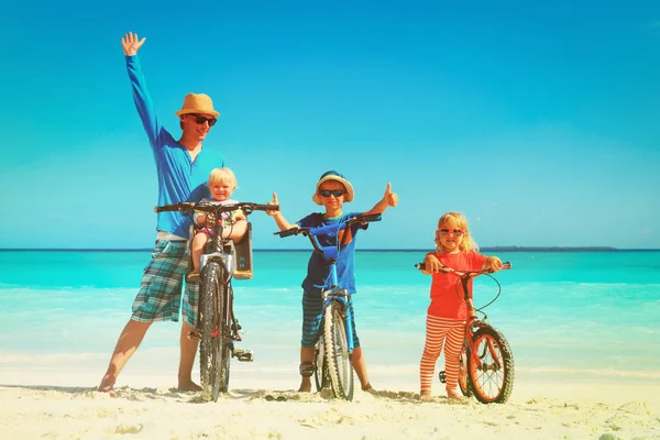 Çocuklar kumsalda bisikleti ile mutlu baba — Stok fotoğraf