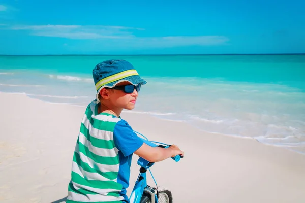 Mały chłopiec jazda rowerem na tropikalnej plaży — Zdjęcie stockowe