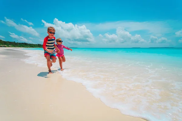 Bambina e ragazzo correre giocare con acqua sulla spiaggia — Foto Stock