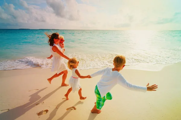 Mutlu aile - tropik sahilde koşmak çocuklar oyun ile anne — Stok fotoğraf