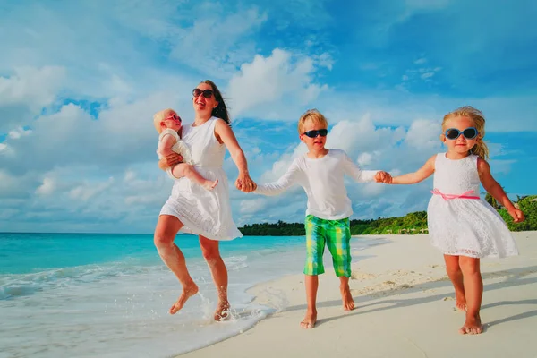 Mutlu aile - tropik sahilde koşmak çocuklar oyun ile anne — Stok fotoğraf