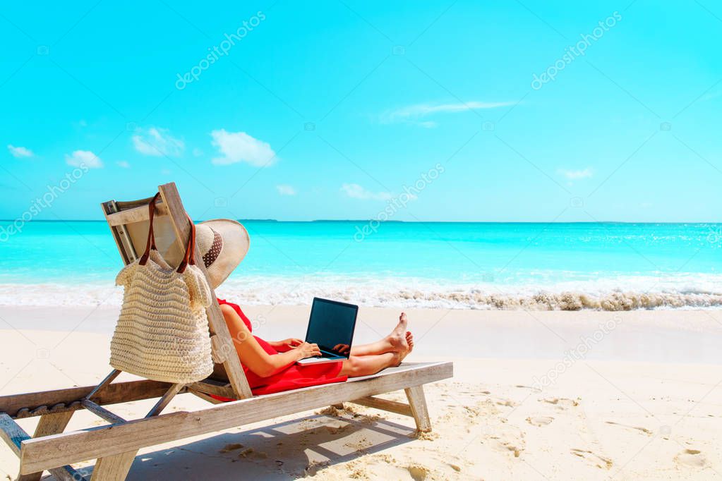 remote work concept -young woman with laptop on beach
