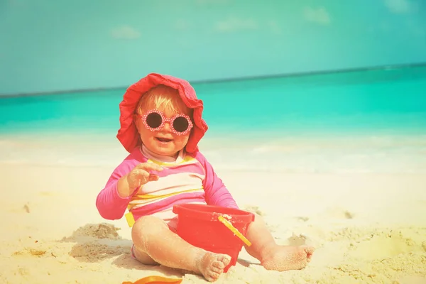 Mignonne petite fille jouer avec le sable sur la plage — Photo