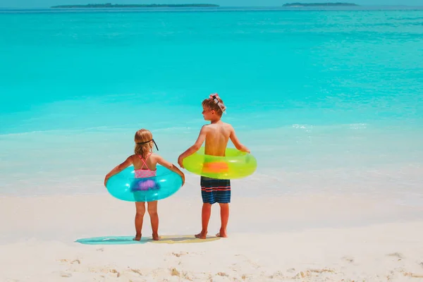 Malou holčičku a chlapce jít plavat na pláži — Stock fotografie