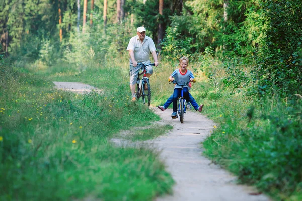 Aktywny senior z wnukami jazda na rowerach w przyrodzie — Zdjęcie stockowe