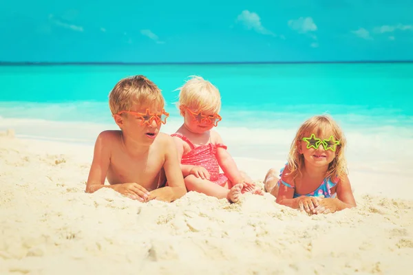 Meninos felizes - menino e meninas brincam com areia na praia — Fotografia de Stock