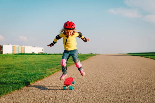 Petite fille apprendre à monter sur skateboard à l'extérieur — Photo