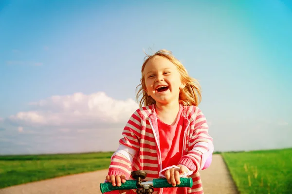 Menina feliz montando scooter no verão — Fotografia de Stock