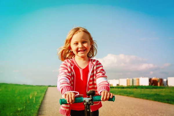 Gadis kecil yang bahagia naik skuter di musim panas — Stok Foto