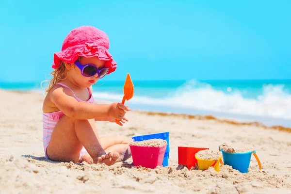 Carino bambina giocare con sabbia sulla spiaggia — Foto Stock