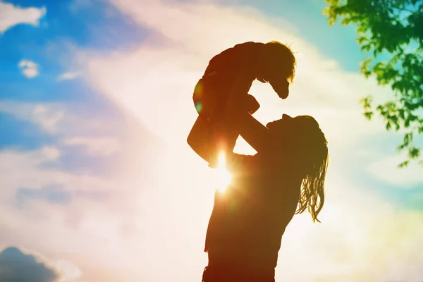 Mãe e bebê brincam ao pôr do sol — Fotografia de Stock