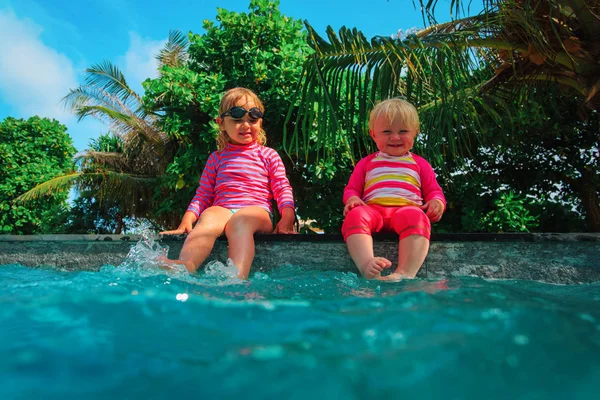 Šťastné děti hrát si s vodou v bazénu tropické Resort — Stock fotografie