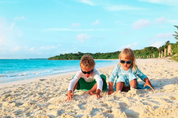 Kleine jongen en meisje plezier spelen zand op strand — Stockfoto