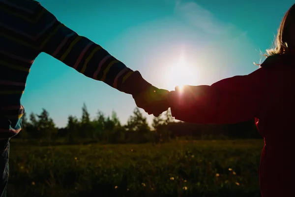 Menino e menina de mãos dadas ao pôr do sol — Fotografia de Stock