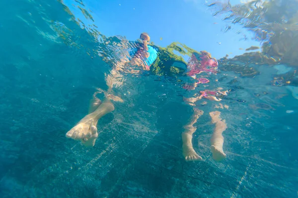 Petit garçon et fille pieds dans la piscine, les enfants jouent de l'eau — Photo