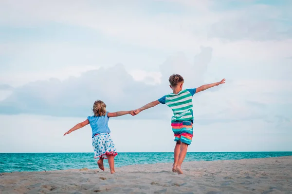 Küçük erkek ve kız plajda oynamak eğlenmek — Stok fotoğraf