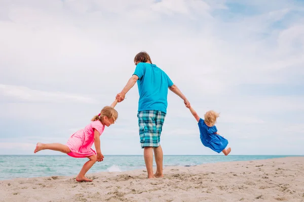 Vader met kinderen spelen op het strand — Stockfoto