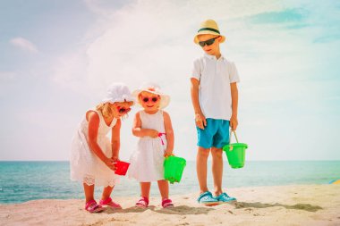 Çocuklar - küçük çocuk ve kız-oyun-kumlu plajda, aile tatil