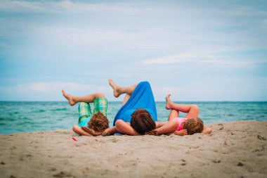 Anne küçük oğlu ve kızı ile rahatlayın plajda oyun