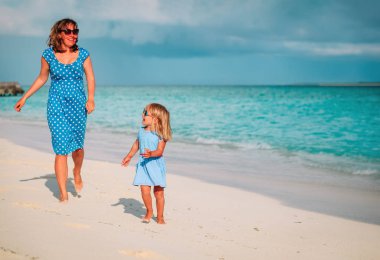 Anne küçük kız ile oynamak üzerinde çalışma tropikal plaj