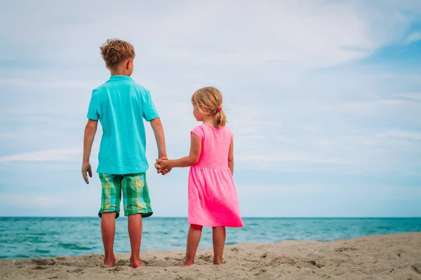 Kleine jongen en meisje lopen op zomer-strand — Stockfoto