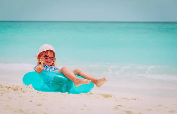 Schattig klein meisje met drijvende ring op strand speelgoed — Stockfoto