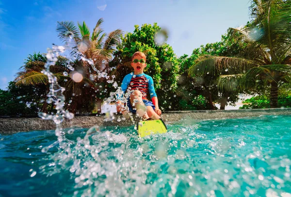 Menino feliz brincar com a água na piscina de resort tropical — Fotografia de Stock