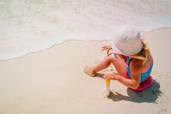 Bescherming tegen de zon - meisje met zonnebrandcrème op strand — Stockfoto