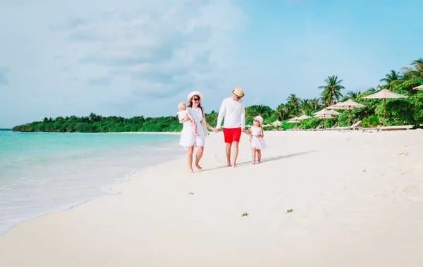Gezin met twee kinderen lopen op tropisch strand — Stockfoto