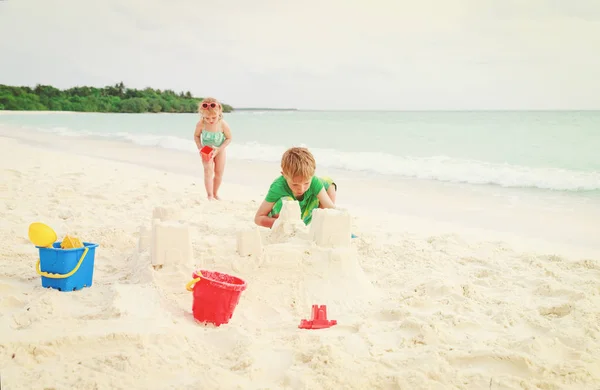 Děti - malý chlapec a dívka hrát s pískem na pláži — Stock fotografie