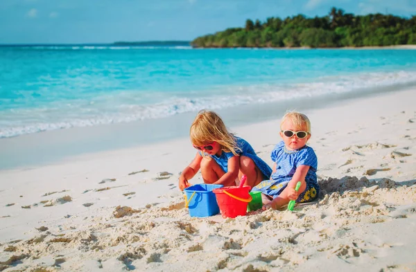 Діти грають з піском на літньому пляжі — стокове фото