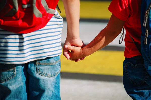 Мальчик и девочка держатся за руки идти в школу — стоковое фото