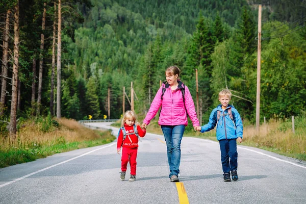iki çocuk seyahat doğada yolda annesiyle