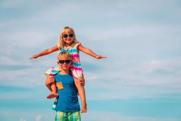 Menino e menina feliz jogar no céu — Fotografia de Stock