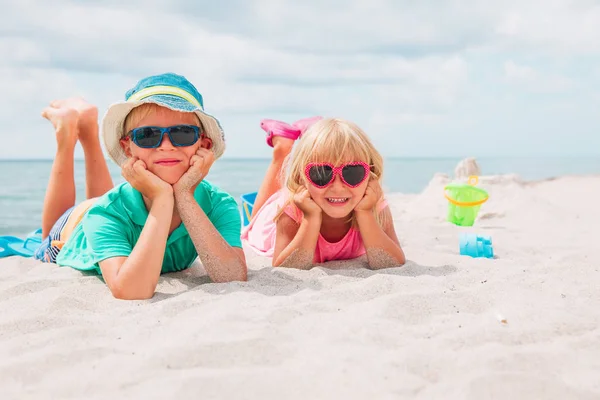 Mignon garçon et fille jouer avec sable sur la plage — Photo