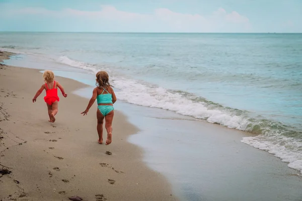 Kleine meisjes uitvoeren Speel hebben plezier op strand — Stockfoto