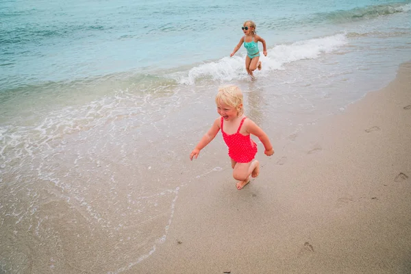 Kleine meisjes uitvoeren Speel hebben plezier op strand — Stockfoto