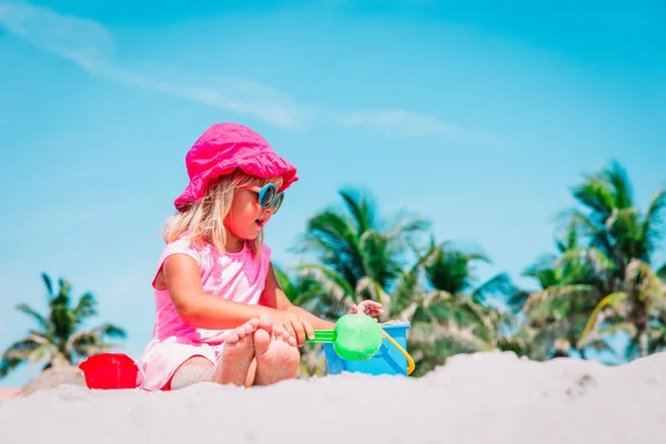Mignonne petite fille jouer avec le sable sur la plage — Photo