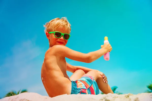 Sun protection - szczęśliwy chłopiec z suncream Beach — Zdjęcie stockowe