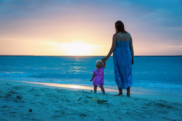 Silueta matku a dceru na pláži při západu slunce — Stock fotografie