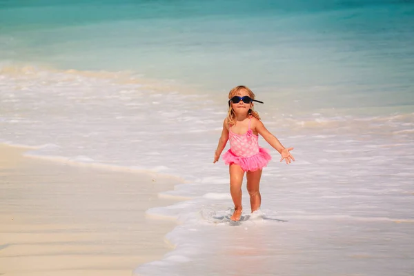 Petite fille courir jouer avec des vagues sur la plage — Photo