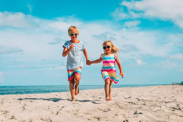 Happy kids-jongen en meisje draait op strand — Stockfoto