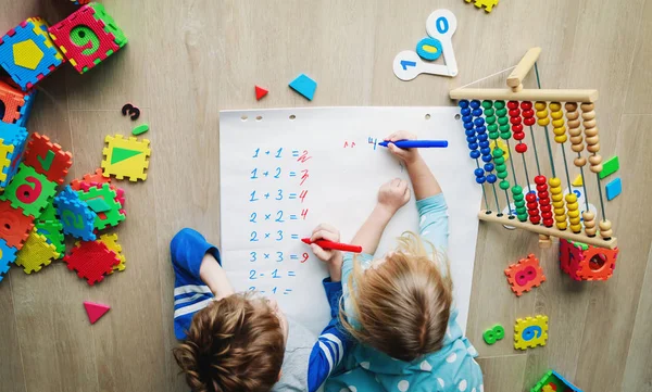 Liten pojke och flicka lära sig skriva och beräkna tal — Stockfoto