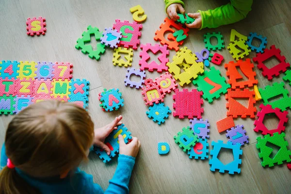 Crianças brincando com quebra-cabeça, aprendendo números — Fotografia de Stock