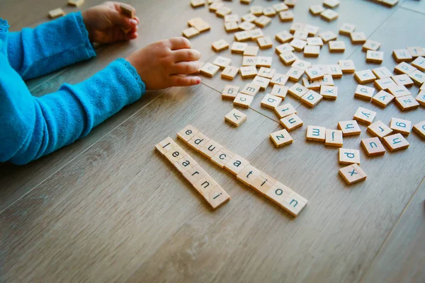 Little girl play with letter puzzle in school or daycare — Stock Photo, Image