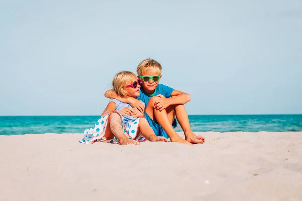 Niños felices - chico y chica, hermano y hermana-abrazo en la playa —  Fotos de Stock