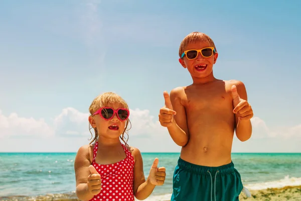 Счастливые симпатичные мальчик и девочка любят играть на пляже — стоковое фото