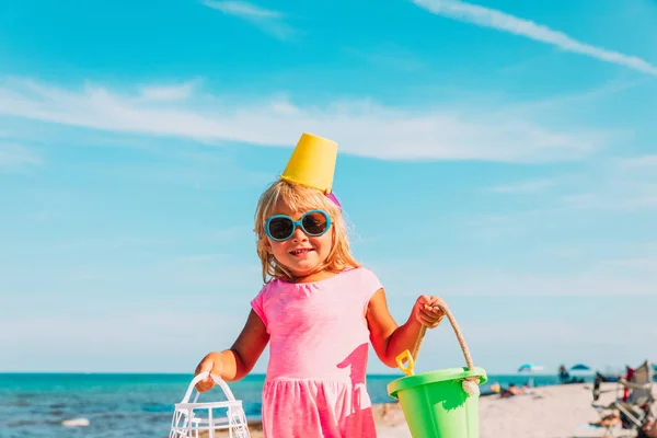 Linda niña con juguetes en la playa pública —  Fotos de Stock