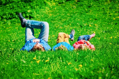 Baba oğlu ve kızı ile sakin yeşil çimenlerin üzerinde